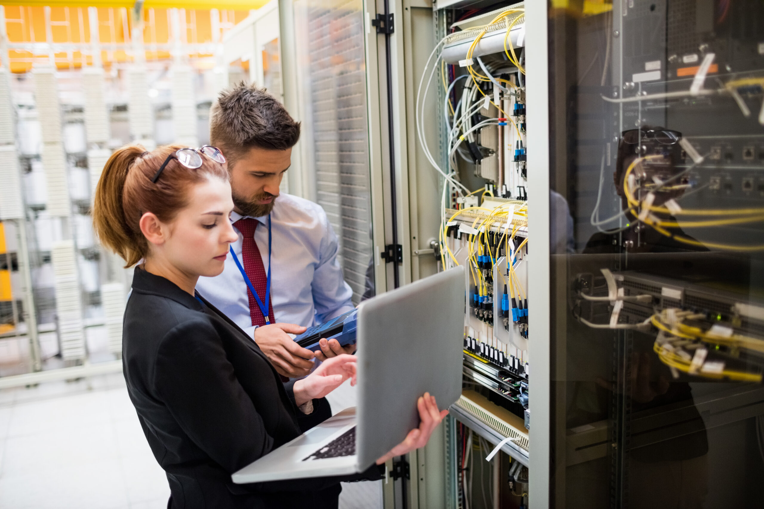 Technicians using laptop while analyzing server in server room; Shutterstock ID 585410489; Purchase Order: comps; Job: ; Client/Licensee: ; Other: