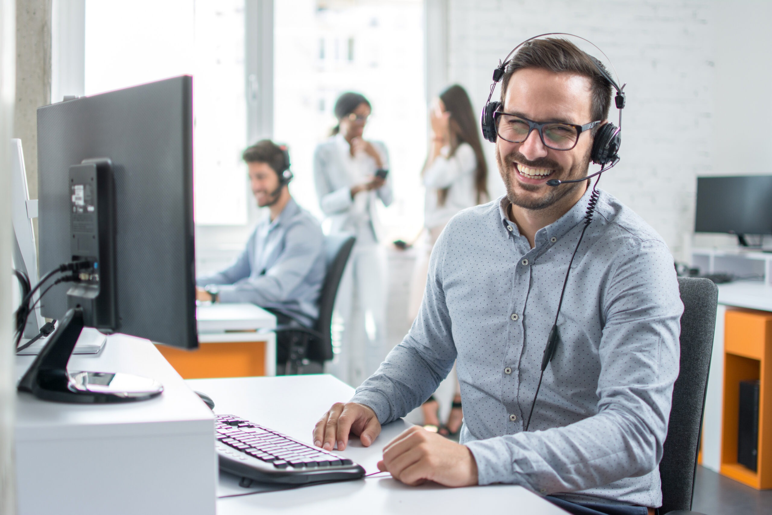 Happy young male customer support executive working in office.; Shutterstock ID 739331605; purchase_order: Limited 10/19/22; job: ; client: ; other:
